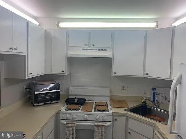 126 Club Pl Unit 126, Absecon, NJ 08205 - kitchen with under cabinet range hood, white electric range oven, light countertops, and white cabinets