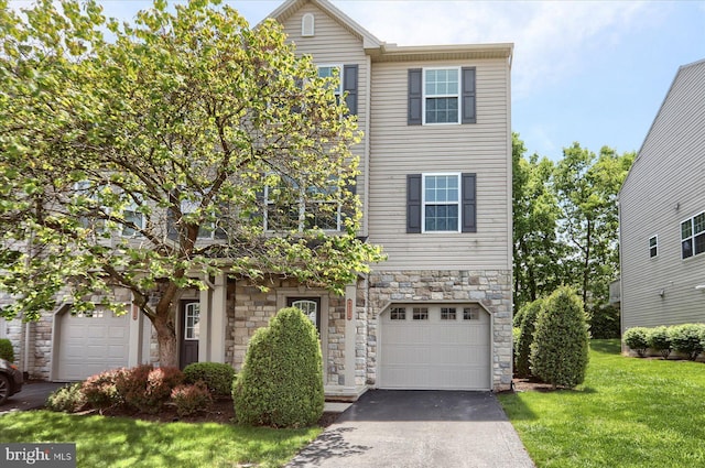 view of front of home featuring stone siding, driveway, a front lawn, and a garage