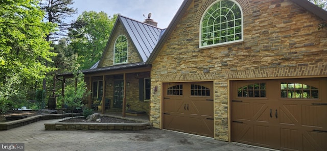 227 Haines Dr, Capon Bridge, WV 26711 - view of front of house with a standing seam roof, a garage, driveway, a chimney, and metal roof