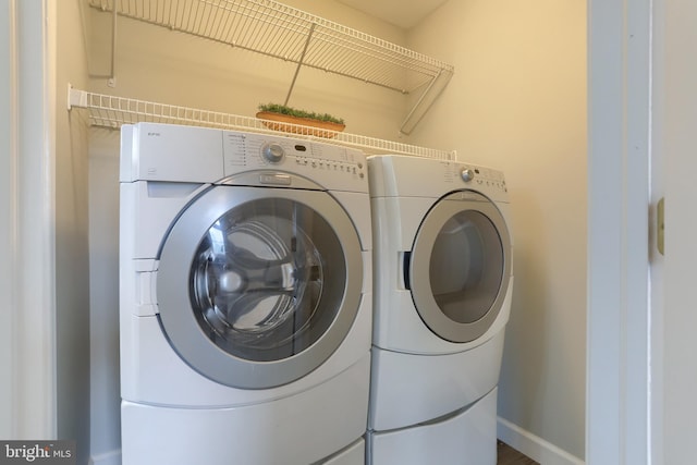 laundry room with washing machine and clothes dryer and baseboards