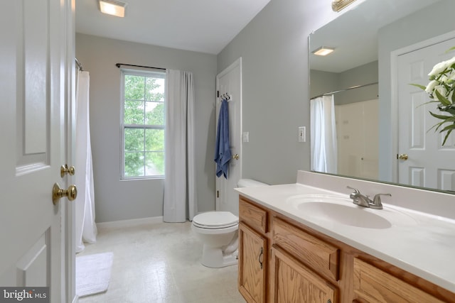 bathroom featuring toilet, vanity, tile patterned floors, and baseboards