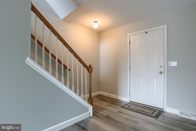 entryway featuring wood finished floors, stairs, and baseboards