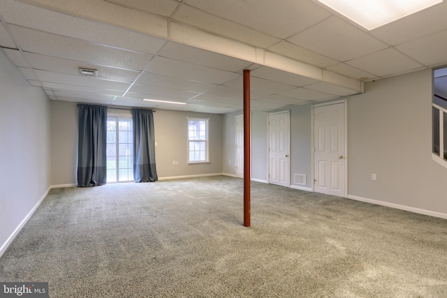 basement with a drop ceiling, carpet, and baseboards