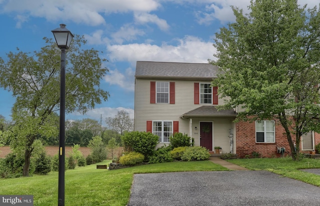 view of front of property with a front lawn and roof with shingles