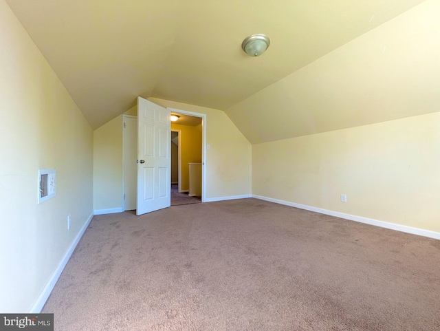 additional living space with carpet flooring, vaulted ceiling, and baseboards