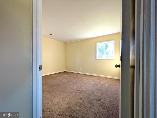 carpeted empty room with baseboards