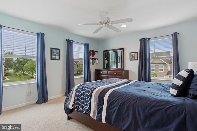 carpeted bedroom featuring baseboards and ceiling fan