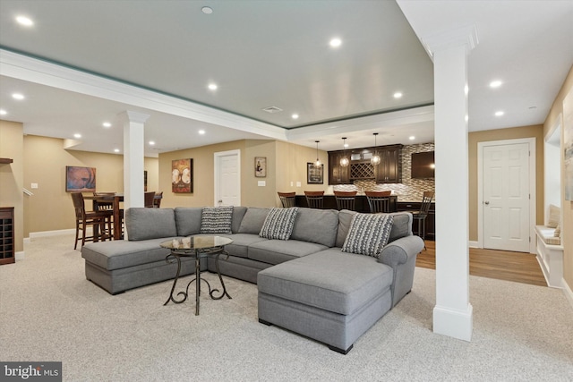 living room with bar area, light colored carpet, ornate columns, recessed lighting, and baseboards