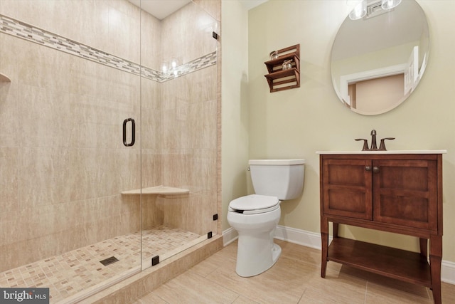 full bathroom with a shower stall, toilet, baseboards, vanity, and tile patterned floors
