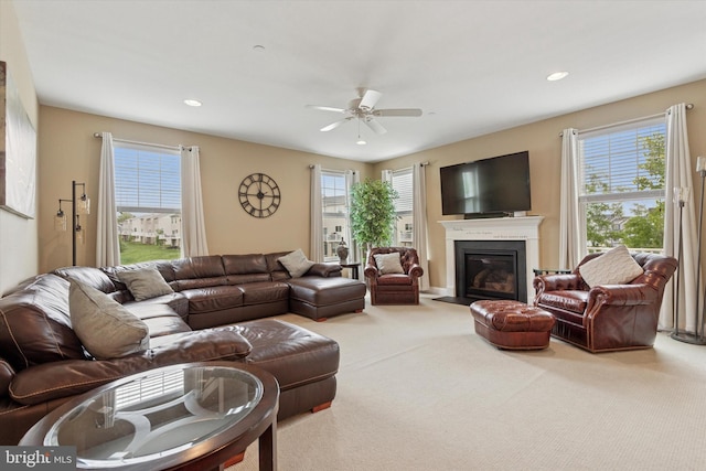 living room featuring a ceiling fan, healthy amount of natural light, carpet, a glass covered fireplace, and recessed lighting