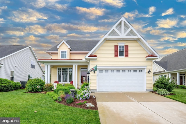 view of front of home with concrete driveway, a lawn, an attached garage, and central AC