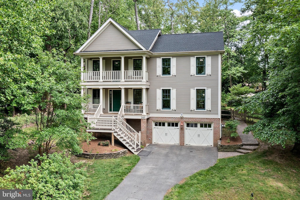 2681 Claibourne Rd, Annapolis, MD 21403 - view of front of house featuring a balcony, a porch, asphalt driveway, stairs, and an attached garage