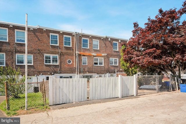 view of front of home featuring brick siding and a gate