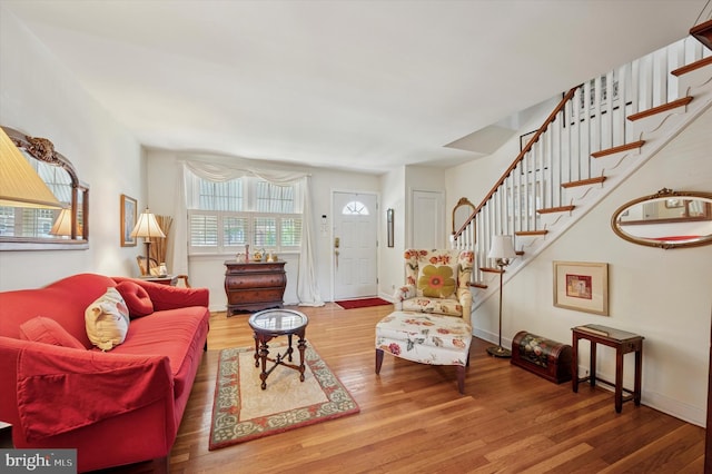 living room with wood finished floors, stairway, and baseboards