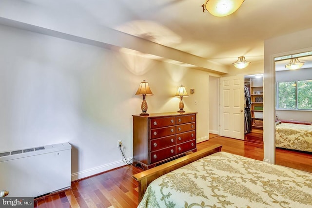 bedroom with wood finished floors and baseboards