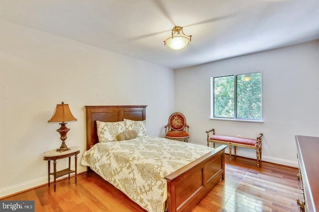 bedroom featuring light wood finished floors and baseboards