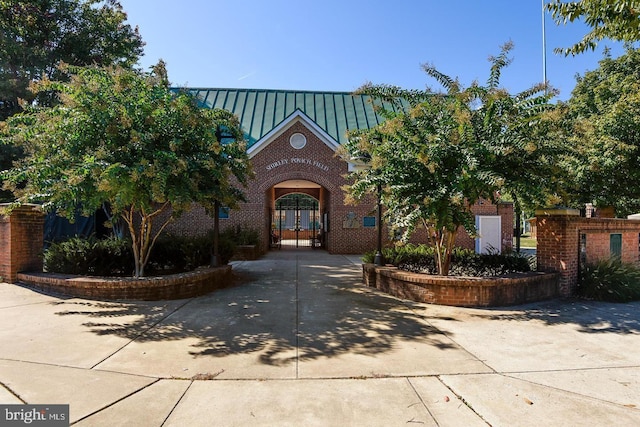 view of front of property featuring french doors, brick siding, a standing seam roof, and metal roof