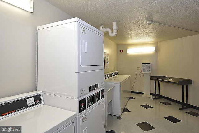community laundry featuring stacked washing machine and dryer, washing machine and clothes dryer, light floors, baseboards, and a textured ceiling