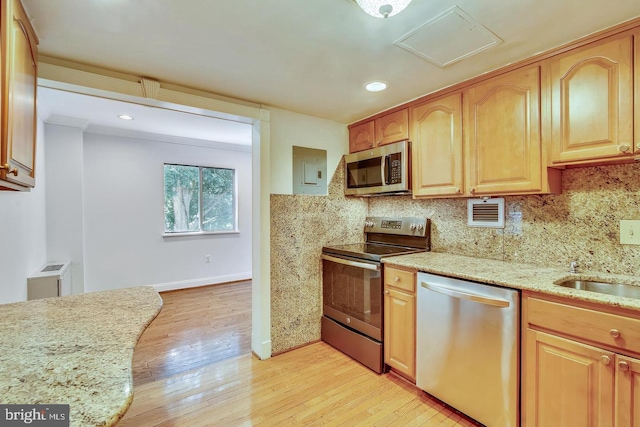 kitchen with appliances with stainless steel finishes, light wood finished floors, light stone countertops, backsplash, and recessed lighting