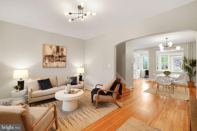 2420 2nd St NE, Washington, DC 20002 - living room featuring a chandelier, arched walkways, wood-type flooring, and baseboards
