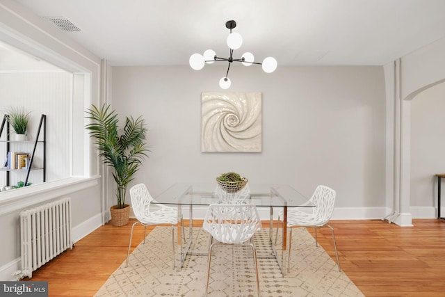 2420 2nd St NE, Washington, DC 20002 - dining room with radiator heating unit, wood finished floors, baseboards, and a chandelier