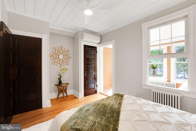 2420 2nd St NE, Washington, DC 20002 - bedroom with radiator heating unit, a wall mounted AC, wood finished floors, multiple windows, and ornamental molding