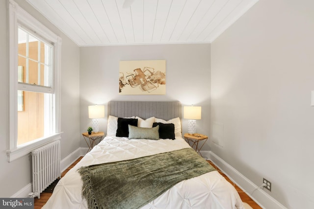 2420 2nd St NE, Washington, DC 20002 - bedroom featuring radiator, multiple windows, baseboards, wood finished floors, and wooden ceiling
