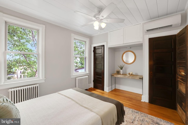 2420 2nd St NE, Washington, DC 20002 - bedroom with radiator heating unit, a wall unit AC, wood finished floors, wood ceiling, and baseboards