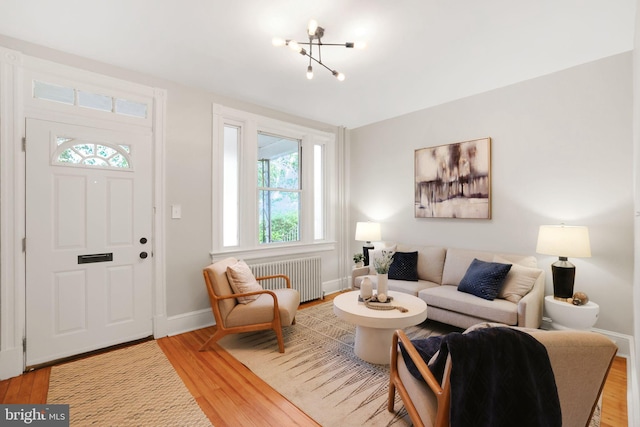 2420 2nd St NE, Washington, DC 20002 - living room with radiator, light wood-type flooring, baseboards, and a chandelier