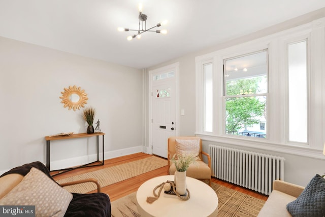 2420 2nd St NE, Washington, DC 20002 - living room featuring radiator, wood finished floors, a chandelier, and baseboards
