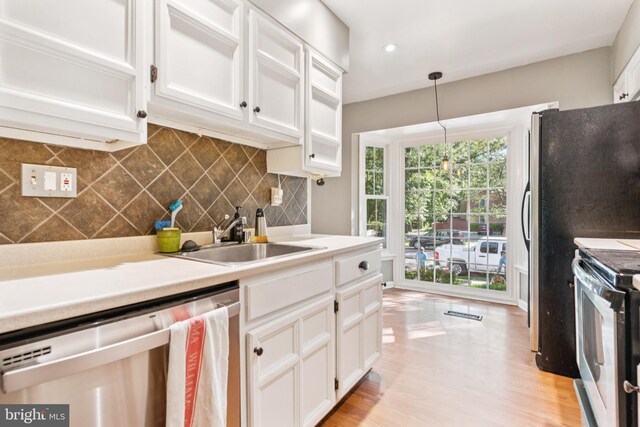 1509 Carlyle Dr Unit 152, Crofton, MD 21114 - kitchen with stainless steel appliances, a sink, white cabinetry, backsplash, and light countertops