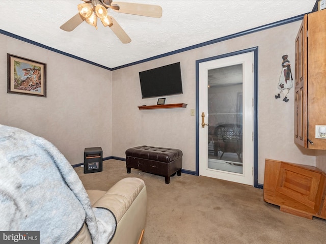 sitting room featuring carpet floors, a ceiling fan, a textured ceiling, and ornamental molding