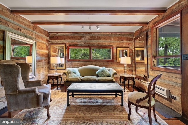 living room featuring plenty of natural light, wood finished floors, wood walls, and beam ceiling