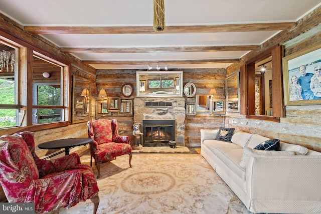 living area with a stone fireplace and beam ceiling