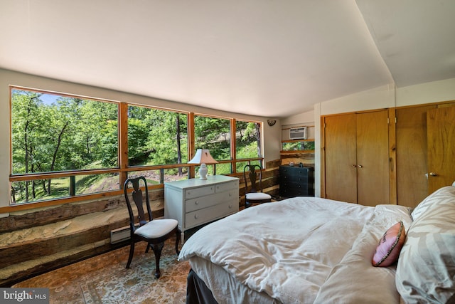bedroom with a wall unit AC, a baseboard heating unit, and lofted ceiling