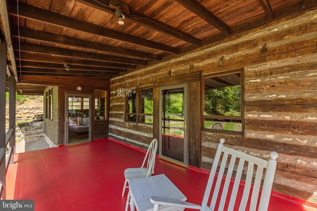 sunroom / solarium featuring beam ceiling