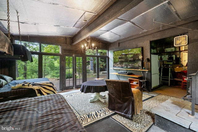 bedroom featuring a chandelier, lofted ceiling, and concrete floors