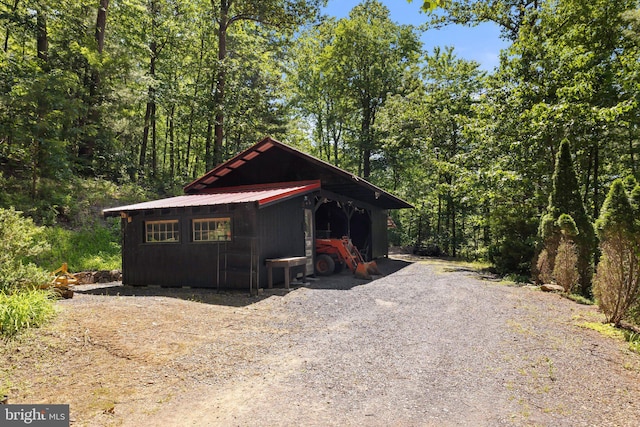 chalet / cabin with metal roof, an outbuilding, and a wooded view