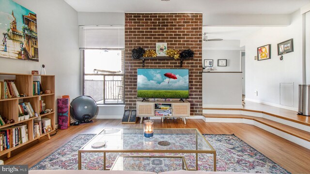 living room featuring wood finished floors, baseboards, and a ceiling fan