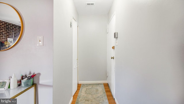 corridor featuring light wood-style floors and baseboards