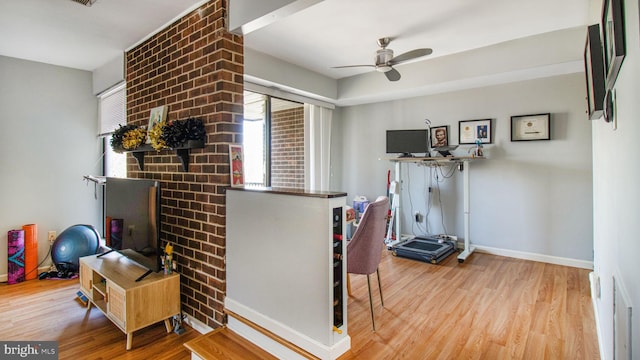 exercise room featuring ceiling fan, wood finished floors, and baseboards