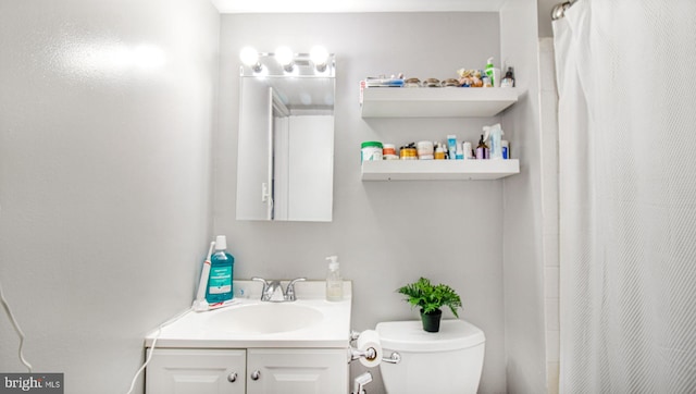 bathroom with toilet, a shower with curtain, and vanity