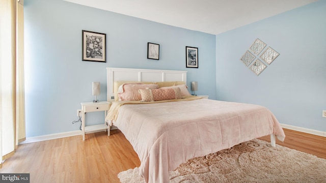 bedroom with light wood-style floors and baseboards