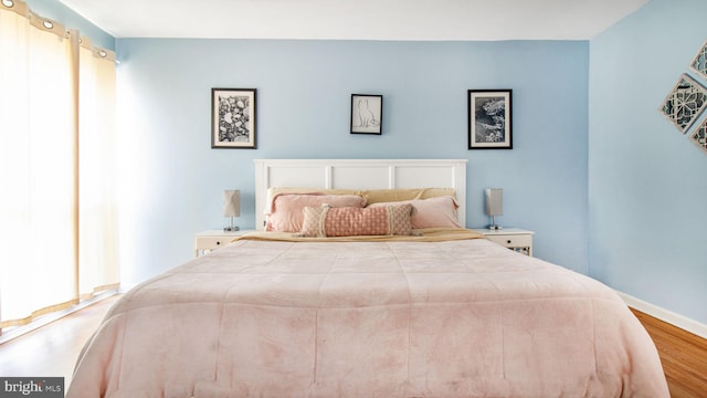 bedroom with wood finished floors and baseboards