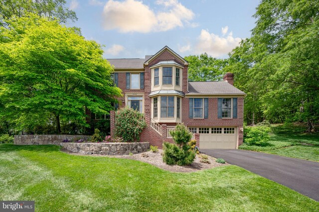 15069 Brown Post Ln, Centreville, VA 20121 - victorian home featuring brick siding, driveway, an attached garage, a front lawn, and a chimney