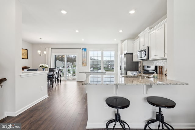 16 Foundry Blvd, Mount Holly, NJ 08060 - kitchen featuring stainless steel appliances, a breakfast bar area, a peninsula, white cabinetry, and light stone countertops