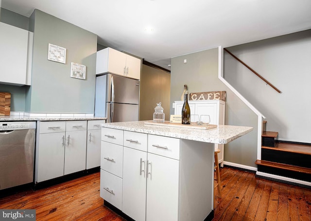 3211 Leverton Ave, Baltimore, MD 21224 - kitchen with stainless steel appliances, dark wood finished floors, white cabinets, a kitchen island, and recessed lighting