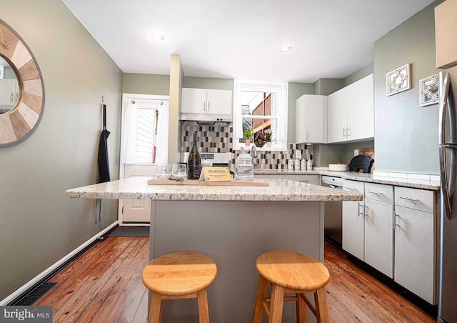 3211 Leverton Ave, Baltimore, MD 21224 - kitchen featuring dark wood-type flooring, a kitchen bar, a center island, white cabinetry, and recessed lighting