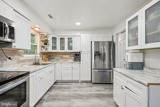 184 Chatham St, Pemberton, NJ 08015 - kitchen with appliances with stainless steel finishes, a sink, white cabinetry, light wood finished floors, and tasteful backsplash