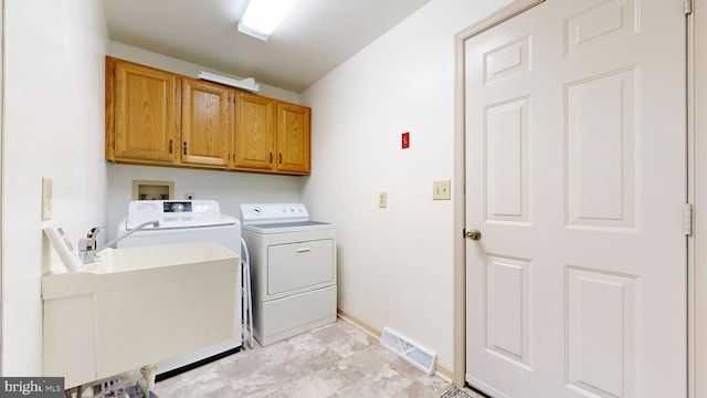 laundry area with separate washer and dryer, cabinet space, and baseboards